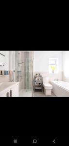 Baño blanco con aseo y lavamanos en Home away from home, en Mildenhall