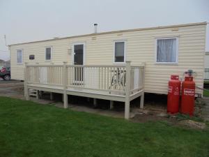 un mobile home avec une terrasse et deux bouches d'incendie dans l'établissement 8 Berth on Sealands New Horizon, à Ingoldmells