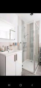 a white bathroom with a shower and a sink at Home away from home in Mildenhall
