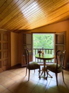 ein Esszimmer mit einem Tisch, Stühlen und einem Fenster in der Unterkunft Casa Can Rufo de Rupit in Rupit