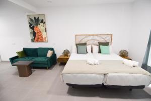1 dormitorio con 1 cama grande y 1 sofá verde en Letmalaga Gazules, en Málaga