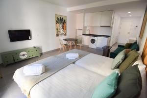 1 cama blanca grande en una habitación con cocina en Letmalaga Gazules, en Málaga