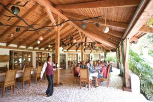 un grupo de personas sentadas en mesas en un restaurante en Dik Dik Hotel, en Arusha