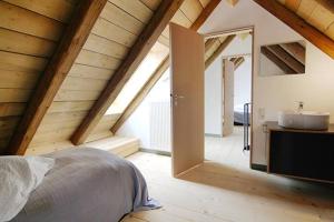 a bedroom with a bed and a sink in a attic at Ferienwohnung Alte Scheune in Schopfheim