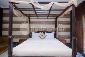 Postel nebo postele na pokoji v ubytování Kebon Krapyak Cottage Syariah Mitra RedDoorz near Stadion Maguwoharjo
