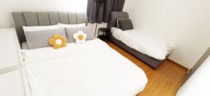 two stuffed teddy bears sitting on top of a bed at Beacon Executive Suites George Town Apartment Malaysia deals in George Town