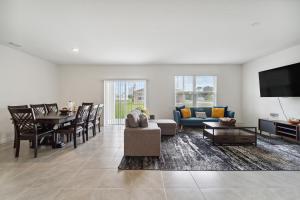 a living room with a couch and a table at Brand New 4-Bedroom House near Disney & Beaches! in Port Saint Lucie
