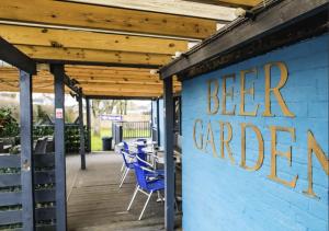 a blue building with a sign that says beer garden at Dog and Partridge Inn in Calne
