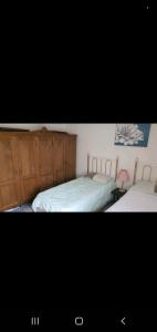 a bedroom with two beds with wooden cabinets at Home away from home in Mildenhall
