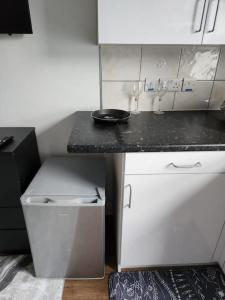 a small kitchen with a black counter and white cabinets at Double room in Stone in Kent