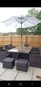 una mesa y sillas con una sombrilla en el patio en Home away from home, en Mildenhall