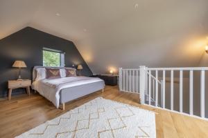 a bedroom with a large bed and a staircase at Granary Cottage in Wenhaston