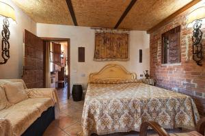 アッバディーア・ディ・モンテプルチャーノにあるAppartamenti Alcantara e Damascoのレンガの壁、ベッド付きのベッドルーム1室