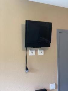 TV de pantalla plana colgada en la pared en La Taverne du Boucher, en Sarlande