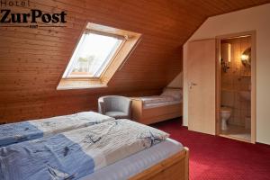 Schlafzimmer im Dachgeschoss mit 2 Betten und einem Fenster in der Unterkunft K357 - Hotel & Restaurant "Zur Post" in Otterndorf bei Cuxhaven in Otterndorf
