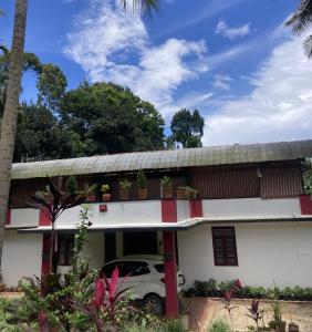 a house with a car parked in front of it at O2 estate stay in Virajpet