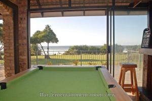 a pool table in a garage with a view of the ocean at Kyalami in Port Edward