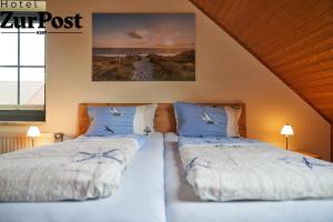 dos camas sentadas una al lado de la otra en un dormitorio en K357 - Hotel & Restaurant "Zur Post" in Otterndorf bei Cuxhaven, en Otterndorf