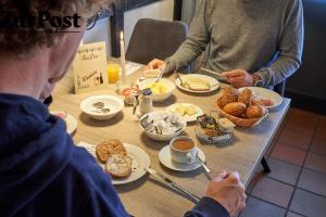 um grupo de pessoas sentadas à mesa a tomar o pequeno-almoço em K357 - Hotel & Restaurant "Zur Post" in Otterndorf bei Cuxhaven em Otterndorf
