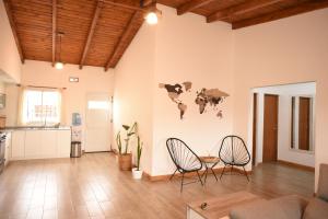 ein Wohnzimmer mit 2 Stühlen und einem Wandbild an der Wand in der Unterkunft Cozy House in San Nicolás de los Arroyos