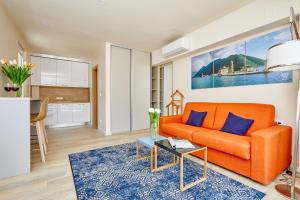 an orange couch in a living room with a table at MAISON W in Kotor