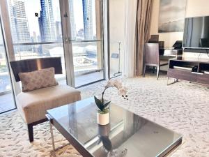ein Wohnzimmer mit einem Sofa und einem Tisch in der Unterkunft Luxury 1 bedroom in Dubai Mall Residences in Dubai