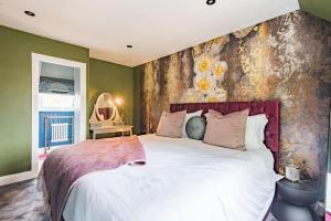 a bedroom with a large bed with a floral wall at Worth Cottage - Perfect for families & friends in Worth