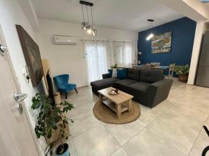 a living room with a couch and a table at Blue Siri Apartment in Heraklio