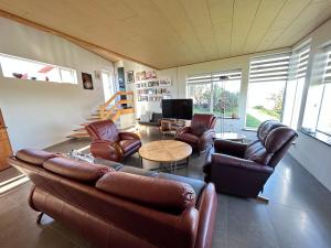 sala de estar con muebles de cuero y TV en Steinsholt - Birta Rentals en Hella