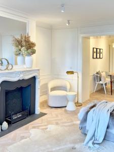 a living room with a fireplace and a chair at MEERBLICK-MAISONETTE Ostseebad Kühlungsborn in Kühlungsborn