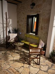patio con sedie, tavolo e finestra di Nikotsaras beach house since 1930 ad Acharavi