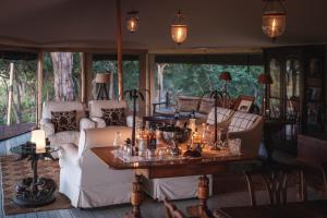 ein Wohnzimmer mit Sofas und einem Tisch mit Kerzen in der Unterkunft Cha Cha Metsi in Maun