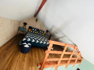 een kleine kamer met een bed en een ladder bij Gîte de la Prévosserie in Rinxent