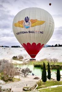 un ballon à air chaud survolant une masse d'eau dans l'établissement Pamukkale Sahin Boutique Hotel, à Pamukkale