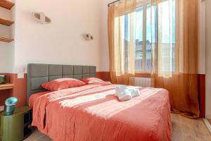 a bedroom with a bed with red sheets and a window at Sublime T4 coeur de ville Jaurès in Limoges +8 photos