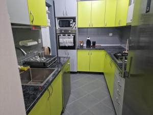 eine Küche mit gelben Schränken und einem Waschbecken in der Unterkunft Boletova kuća na dan in Rumenka