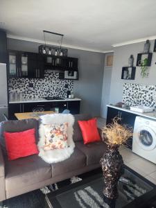 sala de estar con sofá y lavadora en Elite Escape, en Ciudad del Cabo