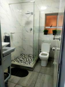 a bathroom with a toilet and a glass shower at Elite Escape in Cape Town