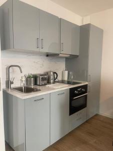 a kitchen with white cabinets and a sink and a stove at Le Cocon Urbain *T2* + Parking in Orléans