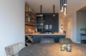 a dining room with a table and chairs and a kitchen at Kleine Krabbe in Tönning