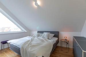 a bedroom with a bed with white sheets and a window at Kleine Krabbe in Tönning