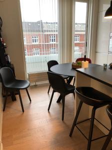 Pokój ze stołem, krzesłami i oknem w obiekcie Thorshavnsgade Apartment w Kopenhadze