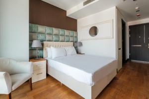 a bedroom with a large white bed and a chair at Studio with City View Balcony 2 min to Metro in Istanbul