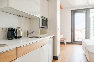 a white kitchen with a sink and a microwave at Studio with City View Balcony 2 min to Metro in Istanbul