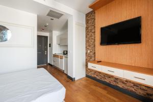 a bedroom with a flat screen tv on a wall at Studio with City View Balcony 2 min to Metro in Istanbul