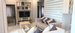 een woonkamer met een bank en een tv bij Luxury Apartment with Sea & Lagoon View  in Negombo