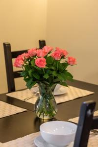 a vase of pink roses sitting on a table at Spokojny Apartament blisko Plaży - Spacerowa - by Renters in Łukęcin