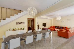 a dining room and living room with a table and chairs at Villa Magda - private pool 22 pax in Marina di Ragusa