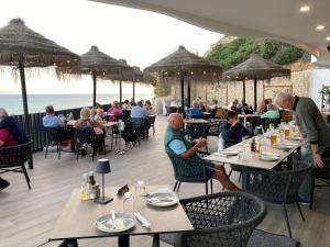 a group of people sitting at tables in a restaurant at Luxury private property-pool, unique sun roof, free wifi in Budens