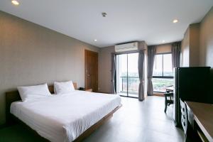 1 dormitorio con 1 cama grande y TV en Farthai Residence, en Phan Thong